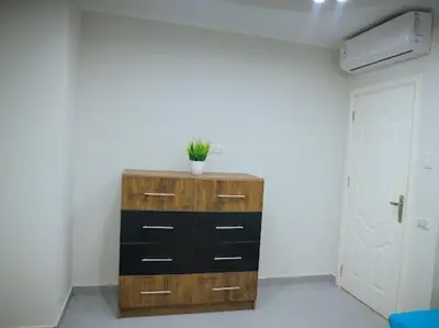 a room with a wooden dresser with a plant on it at Hurghada Scandic in Hurghada