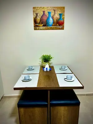 a wooden table with blue chairs and vases on it at Hurghada Holiday Studio with Beach in Hurghada