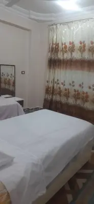 a bedroom with a white bed and a curtain at Sphinx Avenue street in Luxor