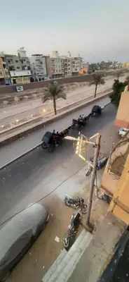 a group of motorcycles parked on the side of a street at Sphinx Avenue street in Luxor