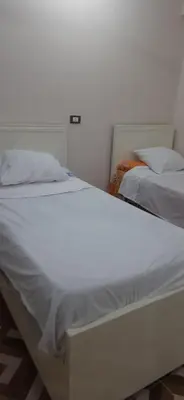 two beds sitting next to each other in a bedroom at Sphinx Avenue street in Luxor