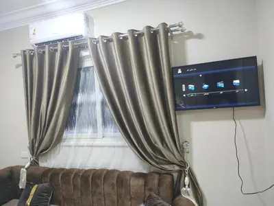a room with a couch and a tv and a window at Fully furnished studio with all services and amenities close to the beach in Hurghada
