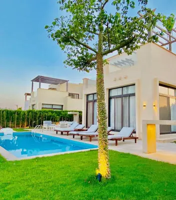 a house with a tree in front of a swimming pool at Luxury villa in gouna in Hurghada