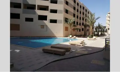 a building with a swimming pool next to a building at princess resort ,arch angilos Hurghada in Hurghada