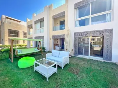 a backyard with a couch and a table and a pool at Luxury 5 Bedrooms Sea Front Villa in Hurghada
