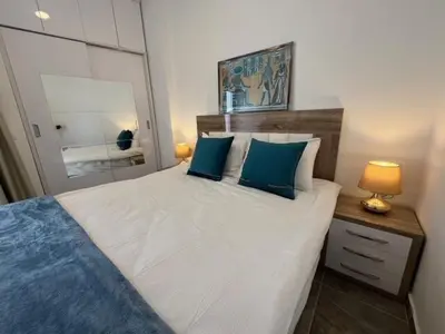 a bedroom with a large white bed with blue pillows at Aqua Infinity Oasis walking distance to beach, 15 minutes from El Gouna, 15 minutes from central Hurghada in Hurghada
