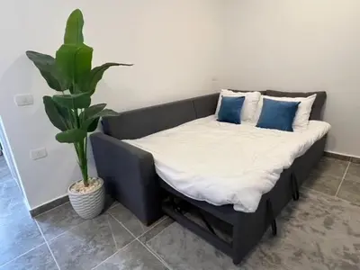 a bed with pillows and a plant in a room at Aqua Infinity Oasis walking distance to beach, 15 minutes from El Gouna, 15 minutes from central Hurghada in Hurghada