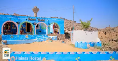 a blue building in the middle of the desert at Heissa Nubian Hostel in Aswân Reservoir Colony