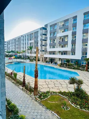 a swimming pool in front of a large apartment building at 005 flamingo building Cozy appartement-two beds-1st floor with elevator in Hurghada