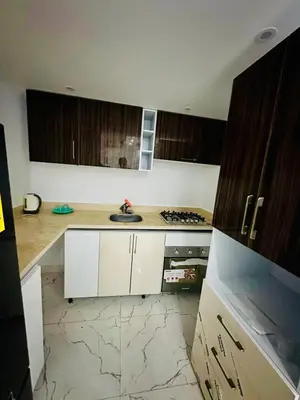 a kitchen with white cabinets and a stove top oven at 005 flamingo building Cozy appartement-two beds-1st floor with elevator in Hurghada