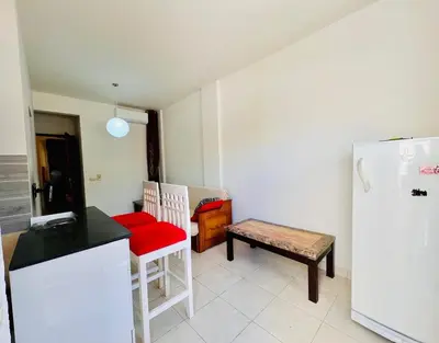 a kitchen with a refrigerator and a table and a chair at Inviting 1-Bed Apartment in Hurgada in Hurghada