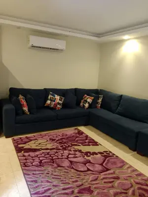 a blue couch in a living room with a rug at Selena Bay Resort in Hurghada