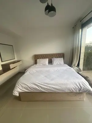a bed in a white bedroom with a large window at G Cribs Hotel Apartment 2BR in Hurghada