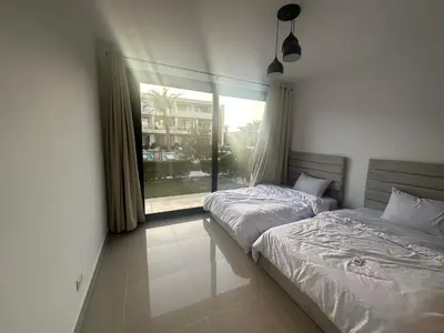 two twin beds in a room with a window at G Cribs Hotel Apartment 2BR in Hurghada