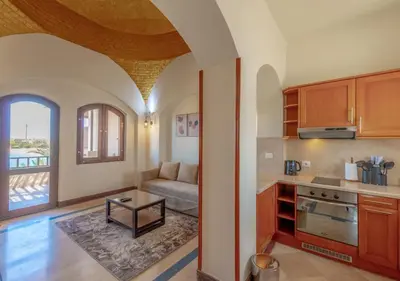 a kitchen with a couch and a table in a room at Dreamy 1BR in Italian Compound, Nubia, El Gouna in Hurghada