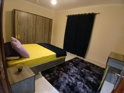 a small bedroom with a yellow bed and a window at Cozy Apartment in Hurghada