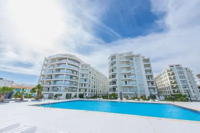 a swimming pool in front of two apartment buildings at Scandic Resort Hurghada مبني سكندك رزوت الغردقة in Hurghada