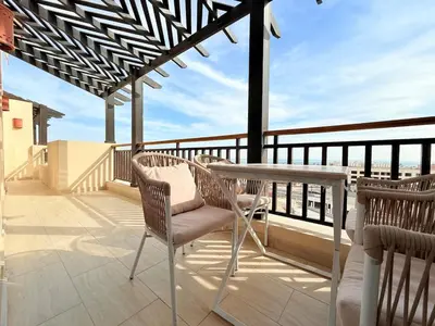 a patio with a table and chairs on a balcony at Luxury hotel apartment 2rooms with triple sea view in Hurghada