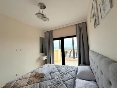a bedroom with a bed and a view of the ocean at Luxury hotel apartment 2rooms with triple sea view in Hurghada