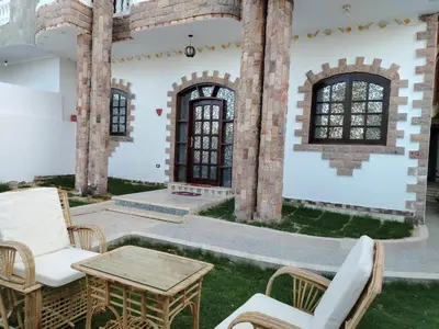 a patio with chairs and a table in front of a building at Mena Palace Nile View in Luxor