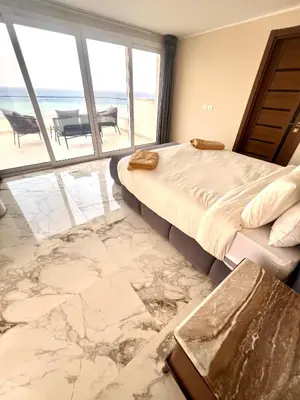 a bedroom with a bed and a view of the ocean at Villa KUBA luxury in Hurghada