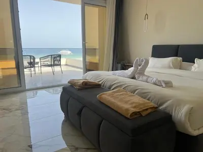 a bedroom with a bed and a ottoman with a view at Villa KUBA luxury in Hurghada