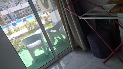 a room with a sliding glass door with two chairs outside at Fanadir Bay apartment in Hurghada