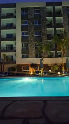 a large swimming pool in front of a building at Fanadir Bay apartment in Hurghada
