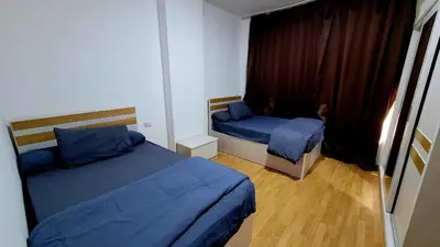 a small bedroom with two beds and a window at touristic centre hurghada in Hurghada