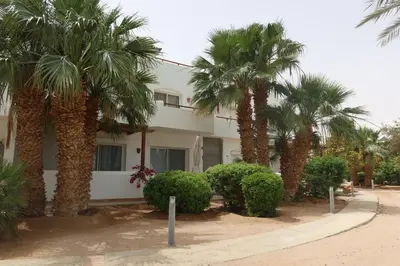 a building with palm trees in front of it at Spacious 1bd on the Beach - White Villas, El Gouna in Hurghada