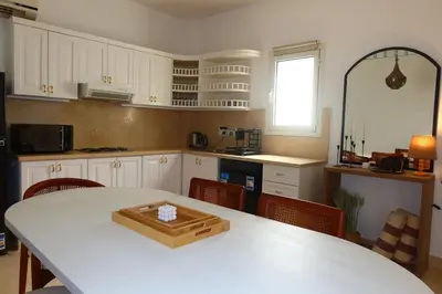 a kitchen with a white table with a wooden tray on it at Spacious 1bd on the Beach - White Villas, El Gouna in Hurghada