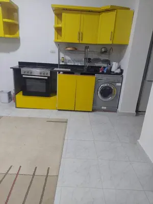 a kitchen with yellow cabinets and a washing machine at Hurghada in Hurghada