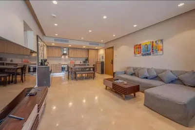 a large living room with a couch and a kitchen at Mangroovy- 1br GF Waterfront Glitzy direct pool in Hurghada