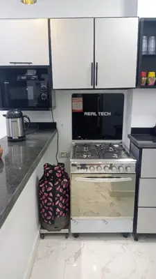 a kitchen with a stove and a microwave at براديس الاحياء in Hurghada