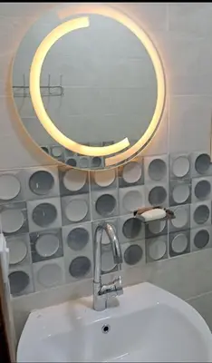 a bathroom with a sink and a round mirror at براديس الاحياء in Hurghada