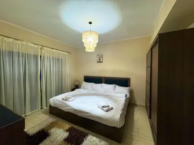 a bedroom with a large bed and a chandelier at Coral Aldau Heights one bedroom apartment in hurghada in Hurghada