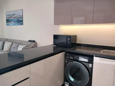 a kitchen with a washing machine and a microwave at Crystal Aldau Heights one bedroom apartment in Hurghada in Hurghada