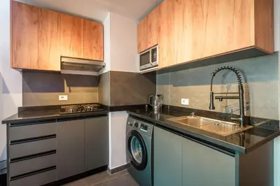 a kitchen with a washing machine and a sink at Al Saraya Sahl Hasheesh by Peaks One Bedroom Apartment with Pool View C201 in Hurghada