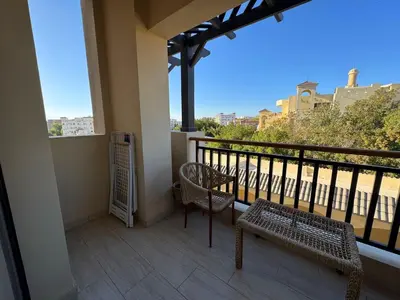a balcony with two chairs and a bench on a balcony at Aldau Heights studio in Hurghada gol in Hurghada