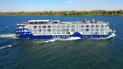 a cruise ship on the water with people on it at Aswan cozy apartment in Aswan
