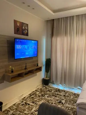 a living room with a flat screen tv on a wall at The Modern Nest Magawish in Hurghada