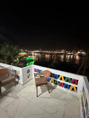 a patio with two chairs and a fence at night at Anno ka in Jazīrat Aswān