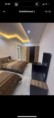 a picture of a bedroom with two beds and a desk at Luxus Apartment in Hurghada