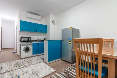 a kitchen with blue cabinets and a washer and dryer at Al Saraya Sahl Hasheesh by Peaks One Bedroom Apartment With Pool View C304 in Hurghada