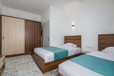 a hotel room with two beds and a tv at Al Saraya Sahl Hasheesh by Peaks One Bedroom Apartment With Pool View C304 in Hurghada