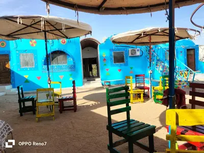 a playground with colorful chairs and umbrellas at Torya guesthouse in Aswan