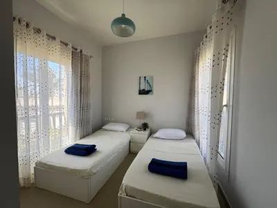 a bedroom with two beds and a window at El Gouna 2 BR Apartment in Hurghada