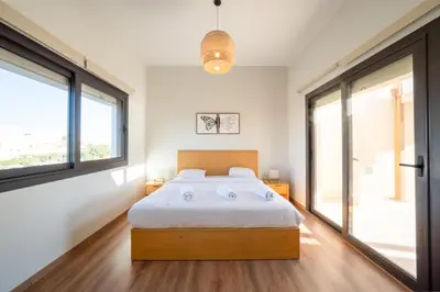 a bedroom with a bed and two windows at Bright Shedwan 3BR • Modern Townhouse in Hurghada