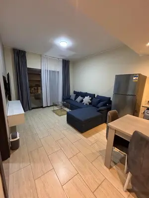 a living room with a blue couch and a table at 1-Bedroom Aldau Heights in Hurghada