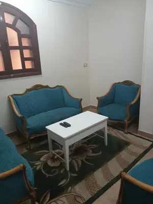 a living room with two chairs and a white table at الاقصر امتداد ش التليفزيون in Al Bayāḑīyah